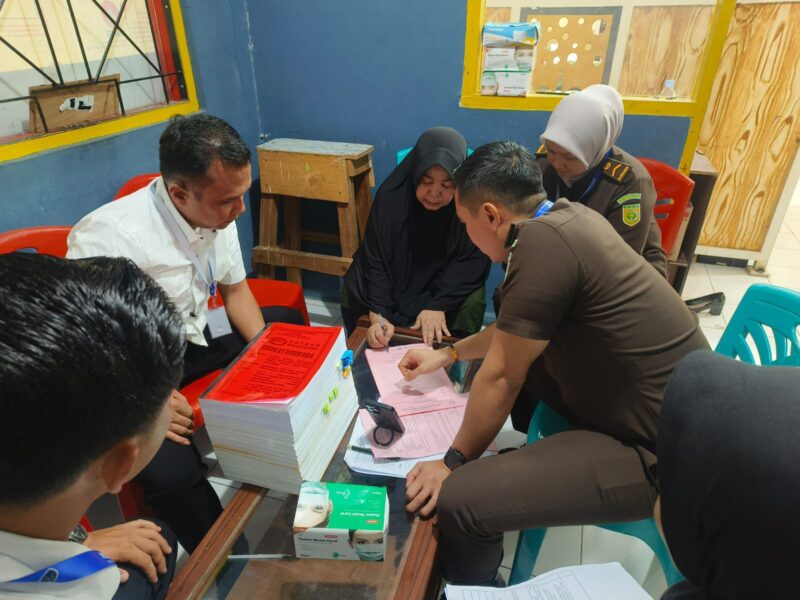 Petugas Satuan Reserse Narkoba Polres Indragiri Hulu saat melakukan pelimpahan tersangka Nurhasanah alias Mak Gadih beserta barang bukti tindak pidana pencucian uang (TPPU) senilai Rp 5,4 miliar ke Jaksa Penuntut Umum Kejaksaan Negeri Inhu, Senin (27/10/2025). Pelimpahan tahap II ini dilakukan setelah berkas perkara dinyatakan lengkap (P21).